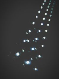 Close-up of illuminated lamp over black background