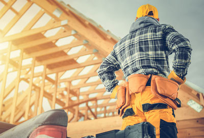 Engineer with hands on hip standing at construction frame