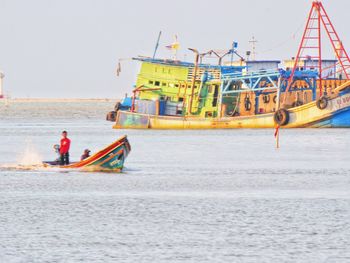 Man fishing in sea against clear sky