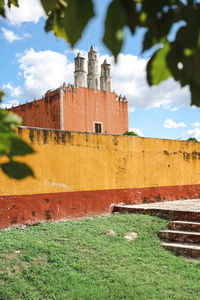 View of chapel with yellow and red wall in rural yucatan mexico.