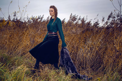 Fashionable woman in a green sweater and a long skirt keeps the fur