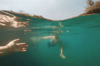 Water surface view of men swimming in sea