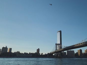 View of bridge and buildings against clear sky