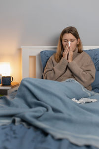 Sick woman resting on bed