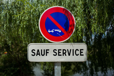 Close-up of no parking sign against trees