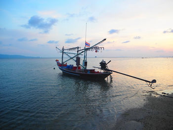 Boats in sea against cloudy sky