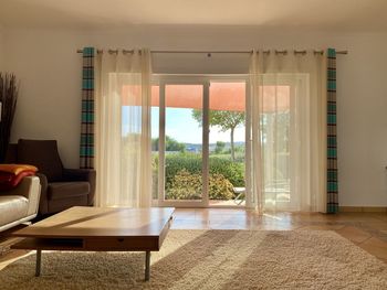 Living room with sunlight filtering in through sliding glass doors