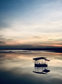 Scenic view of lake against sky at sunset