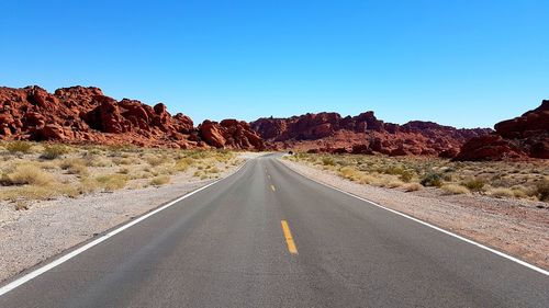 Road by mountain against clear sky