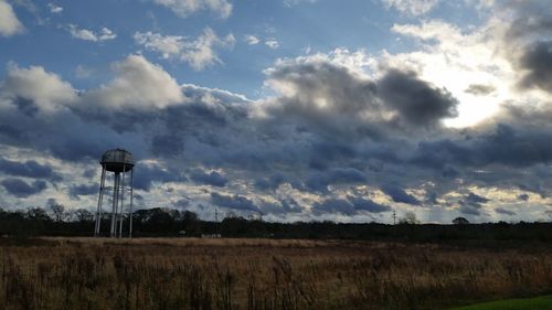 Scenic view of grassy field against cloudy sky