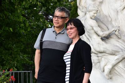 Senior couple standing against statue