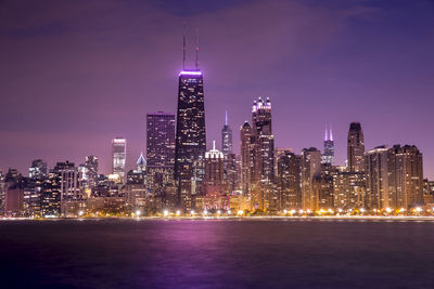 Illuminated buildings against sky at night