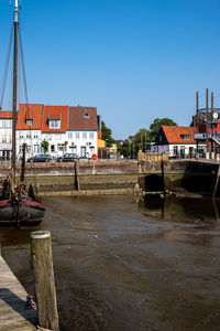 River by buildings against clear sky