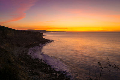 Scenic view of sea against orange sky