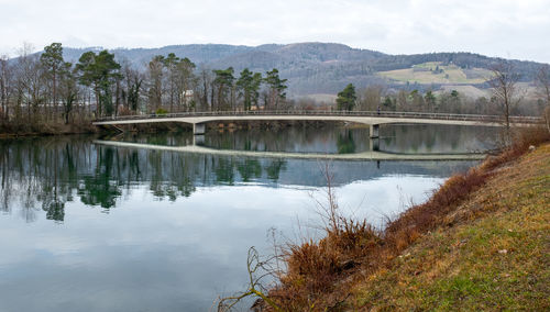 Arch bridge over lake against sky