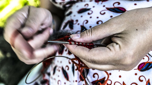 Midsection of woman knitting wool