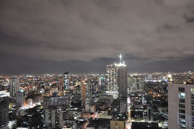 Illuminated buildings in city against sky at night