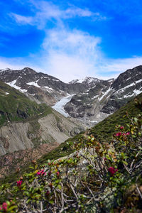 Scenic view of snowcapped mountains against blue sky