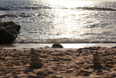 Pebbles on beach against sky during sunset