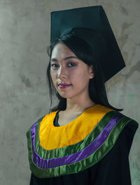 Portrait of beautiful woman standing against wall