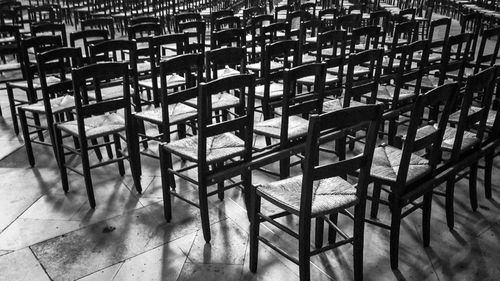 Empty chairs and tables in tiled floor