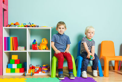 Full length portrait of boys sitting in classroom