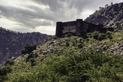 Mountains surrounding abandoned ruined fort in a place named ajabgarh on a way to bhangarh