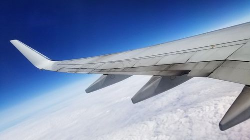 Airplane wing against clear blue sky