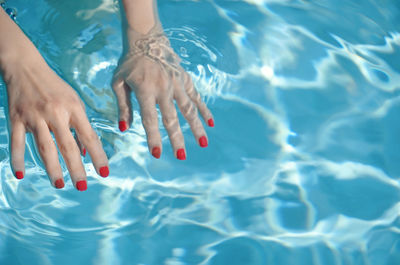 Low section of woman standing in swimming pool