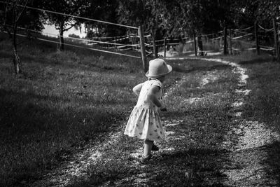 Rear view of woman walking on field