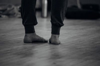 Low section of woman standing on hardwood floor