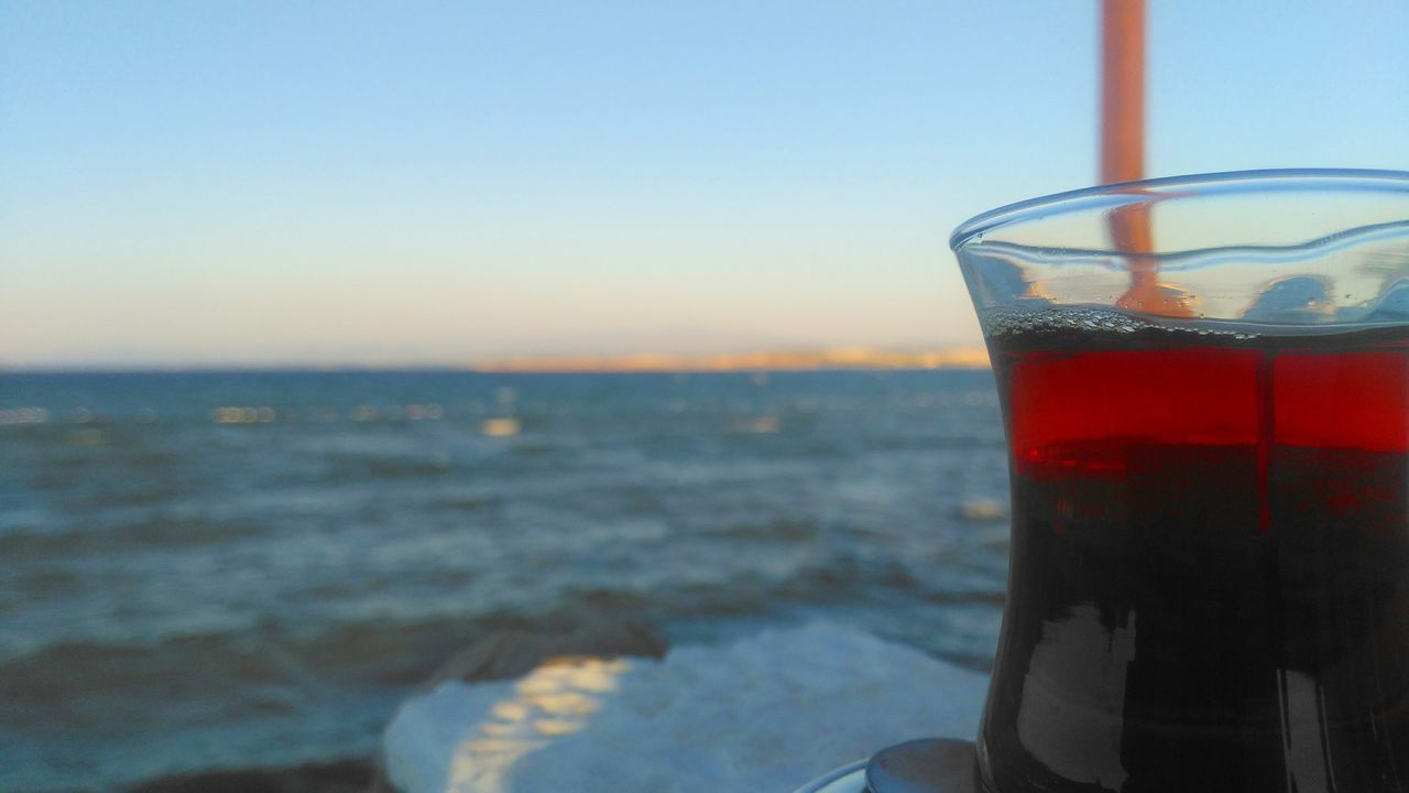 drink, refreshment, drinking glass, food and drink, sea, water, close-up, freshness, sky, no people, focus on foreground, outdoors, horizon over water, sunset, nature, clear sky, day, alcohol, beauty in nature