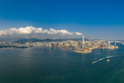 City at waterfront against blue sky