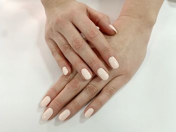 Close-up of woman hand over white background