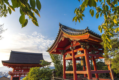 Low angle view of temple by building against sky