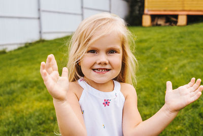 Portrait of cute girl standing on grassy land