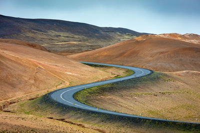 Road leading towards mountains against sky