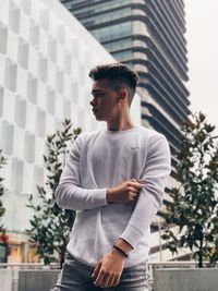 Young man looking away in city