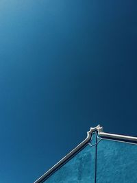 Low angle view of telephone pole against clear blue sky