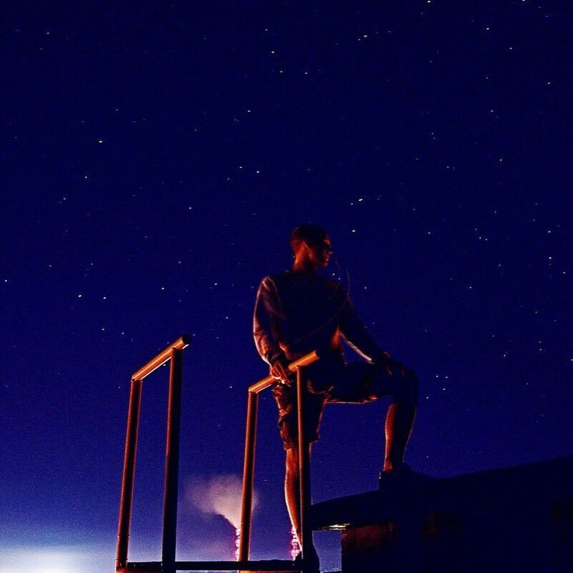 REAR VIEW OF SILHOUETTE MAN STANDING AGAINST SKY