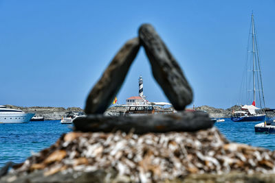 Sailboat by sea against clear blue sky