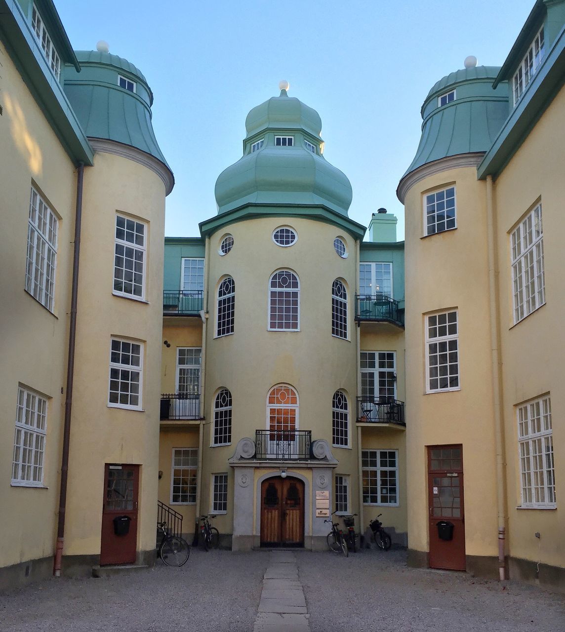 architecture, building exterior, built structure, window, facade, residential building, clear sky, street, building, residential structure, sky, cobblestone, day, arch, sunlight, outdoors, city, old town, house, no people