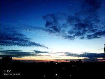 Silhouette buildings against sky at sunset