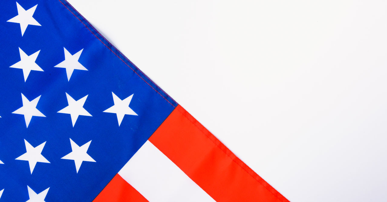 LOW ANGLE VIEW OF FLAG AGAINST CLEAR BLUE SKY