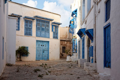 Alley amidst buildings in city against sky