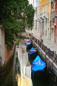 Boats moored on canal in city