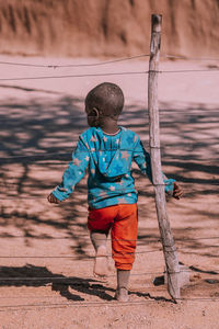 Rear view of boy standing on land