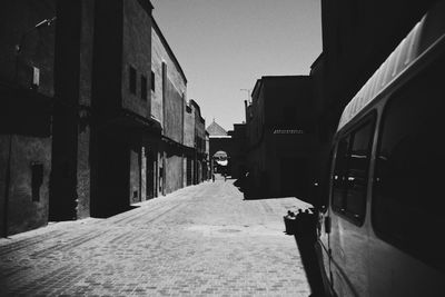 Narrow alley amidst buildings in city against clear sky
