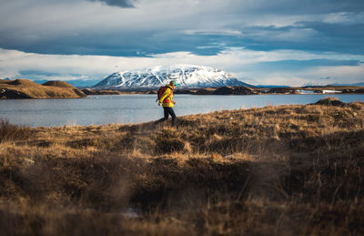 Full length of man standing on riverbank against sky