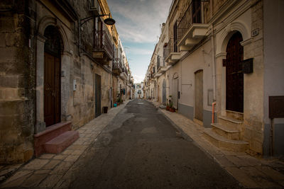 Empty street amidst buildings in town